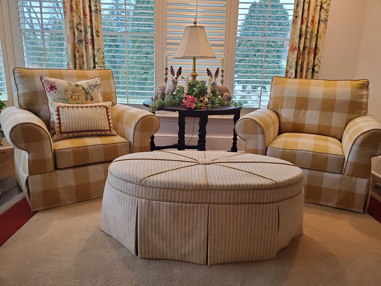 Buffalo-check upholstered armchairs, a skirted round ottoman, and floral drapery panels handcrafted by Creative Stitches Workroom in Grand Blanc, MI.